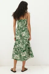 Vestido midi verde con estampado floral blanco, breteles finos ajustables, escote cuadrado, espalda fruncida y falda con vuelo.