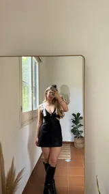 Minivestido negro con brillos, escote en V, breteles finos plateados, cintura ajustada y aberturas laterales.