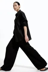 Pantalón negro de punto con cintura elástica y cordón ajustable. Corte holgado con piernas anchas y tiro alto.