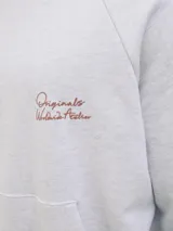 Canguro gris melange con capucha, mangas largas y estampado en la espalda con la inscripción "Studio Originals Edition" en color marrón.