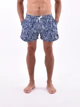 Short de baño azul con estampado de hojas blancas, cintura elástica con cordón ajustable y bolsillos laterales.