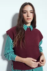 Chaleco tejido sin mangas de color negro, con cuello redondo y diseño de textura sutil. Presenta un corte recto con terminaciones acanaladas en el ruedo y hombros levemente estructurados.