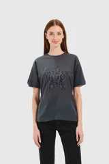 Remera gris topo de corte holgado con cuello redondo y mangas cortas. Presenta una estrella central con aplique de encaje.