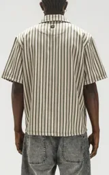 Camisa oversize de manga corta con cuello abierto y estampado a rayas verticales en tonos verde y beige.