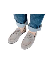 Mocasín gris de cuero gamuzado con lazo frontal y detalle de pasacintas laterales. Suela flexible antideslizante.