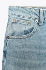 Pantalón de jean celeste de corte amplio, tiro medio, con cinco bolsillos y detalle de costuras torcidas.