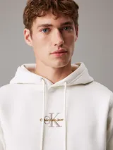 Buzo de felpa color blanco con capucha y cordones ajustables. Tiene puños y bajo acanalados. Presenta el monograma de Calvin Klein bordado en el pecho.