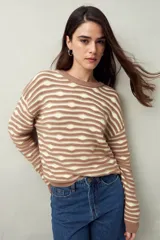 Sweater de punto color beige con rayas horizontales marrones en relieve, cuello redondo y mangas largas.