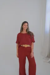 Pantalón de lino color bordó, de corte recto y tiro medio, con cinturón de soga beige.