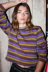 Sweater tejido en mezcla de hilo con lurex, con rayas horizontales color violeta, dorado y marrón. Diseño crop oversize con calce relajado y hombro caído.