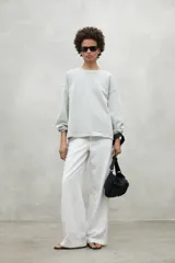 Buzo color gris claro de algodón orgánico y reciclado, con cuello redondo y mangas largas.