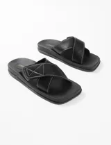 Sandalias negras con tiras cruzadas y costuras blancas en contraste.
