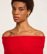 Blusa roja de punto canelado con escote hombro a hombro y mangas largas.