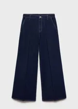 Conjunto de camisa y pantalón de jean azul oscuro. La camisa es de corte recto, con cuello clásico y mangas largas. El pantalón es wide leg, de tiro alto y con bolsillos laterales.