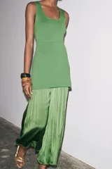 Vestido largo verde con escote redondo y sisas amplias. La parte superior es de punto liso y la falda es plisada de tejido satinado.