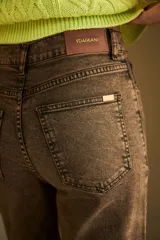 Pantalón de jean color marrón con efecto lavado, corte Oxford de pierna ancha y tiro medio alto. Presenta aberturas en el ruedo.