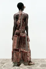 Vestido largo con estampado cachemir en tonos marrones, cuello halter con cordones con abalorios, nido de abeja elástico en la cintura, forro interior y tejido con hilo metalizado.