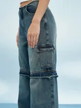 Pantalón de jean azul de corte ancho con aberturas a la altura de las rodillas.