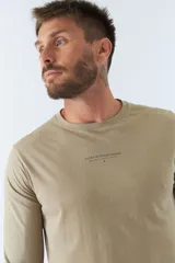 Remera blanca de manga larga con cuello redondo y logo estampado en el pecho.