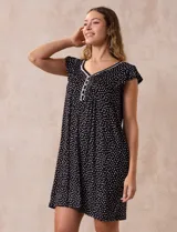 Camisón corto negro con estampado de lunares blancos, escote en V con puntilla blanca y botones.