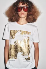 Camiseta blanca de corte recto y manga corta, con estampado frontal de una fotografía en blanco y negro y texto "Amsterdam 74".