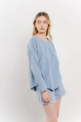 Remera celeste de manga larga con cuello redondo y bolsillo en el pecho.