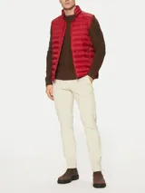 Chaleco rojo Tommy Hilfiger plegable, con cuello chimenea, cierre de cremallera, dos bolsillos laterales con cremallera y logo bordado en el pecho. Confeccionado en tejido de nailon que repele el agua.