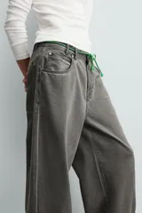 Pantalón de jean gris de corte amplio, estilo balloon fit, con cinco bolsillos, cierre frontal con cremallera y botón, y efecto de color lavado en toda la prenda.