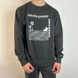 Buzo negro de algodón con cuello redondo y puños acanalados. Estampado blanco en el frente con palmeras, olas y texto "Endless Summer Santa Barbara".