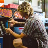 Camisa de manga corta con cuello cubano y estampado geométrico en tonos burdeos, gris y ocre.