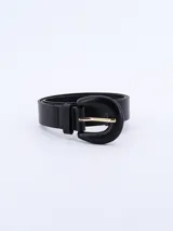 Cinturón negro de cuero sintético con hebilla grande de forma curva y color negro mate, con pasador metálico dorado.