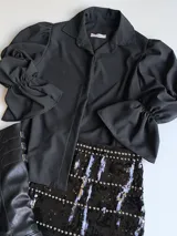 Minifalda negra de lentejuelas con tachas plateadas y cintura elastizada.