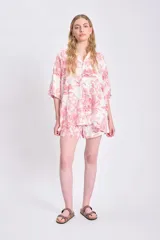 Camisa de manga corta oversize de lino con estampado de palmeras y animales en color rojo sobre fondo blanco.