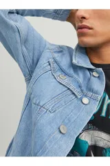 Chaqueta de denim azul con manga larga, cuello extendido y cierre con botones frontales.