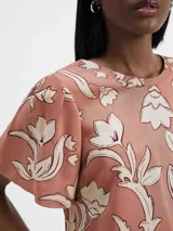 Blusa de manga corta con estampado floral en tonos rosados y blancos.