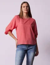 Blusa de gasa color blanco con estampado de hojas verdes, de mangas 3/4 abullonadas con puños elásticos.