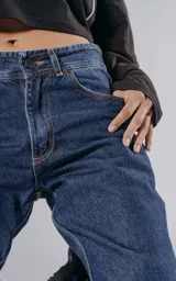 Pantalón de denim azul con cinco bolsillos y corte wide leg.