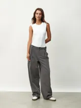 Pantalón gris oscuro de vestir con pinzas, corte amplio y tiro alto.