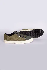 Zapatillas bajas color beige claro, con cordones y suela blanca.