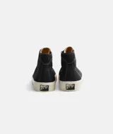 Championes de caña alta de lona negra con cordones blancos y suela de goma color crema.