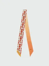 Cinta de seda Longchamp con estampado de bolsos Le Pliage en tonos naranja y blanco.