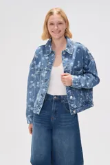 Campera de jean azul con estampado floral blanco, corte holgado, cuello camisero, cierre frontal con botones y bolsillos delanteros.