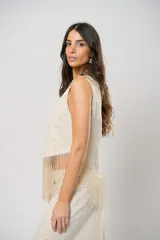 Blusa beige de lino bordado, sin mangas y con terminación en flecos.