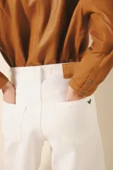 Pantalón jean blanco de corte oxford, tiro alto y largo midi.