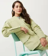Campera parka color verde claro, de corte holgado, con cuello en V, bolsillos delanteros y puños abotonados.