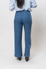 Conjunto de camisa de manga corta con cuello y pantalón de corte recto, ambos de tela simil lino color beige con bordados blancos.