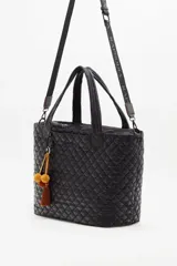 Maxi bolso negro matelase con dos tiras cortas para llevar al hombro o en la mano y una correa regulable y desmontable. Acceso principal con cierre y bolsillo interno. Trae llavero decorativo con pompones de lana.