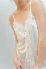 Camisón corto color blanco de satén elastizado con breteles finos y escote en V con detalle de puntilla elastizada en el escote y al centro de la delantera en el largo, espalda recta con puntilla.