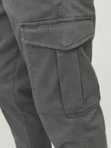 Pantalón cargo gris oscuro, corte slim fit, con puños elastizados, tiro medio, cierre con cremallera y múltiples bolsillos.