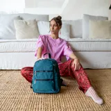 Mochila color beige de tafeta con apertura superior con cierre y tiradores metálicos. Incluye bolsillos internos, bolsillo con doble cierre metálico al frente, asas rígidas de mano y correas regulables para colgar en la espalda.